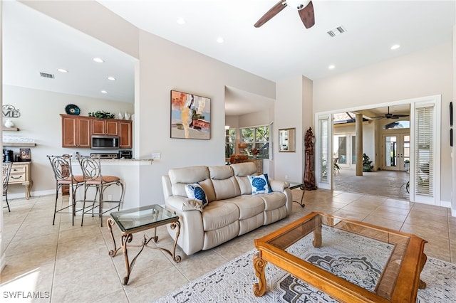 tiled living room featuring ceiling fan and french doors