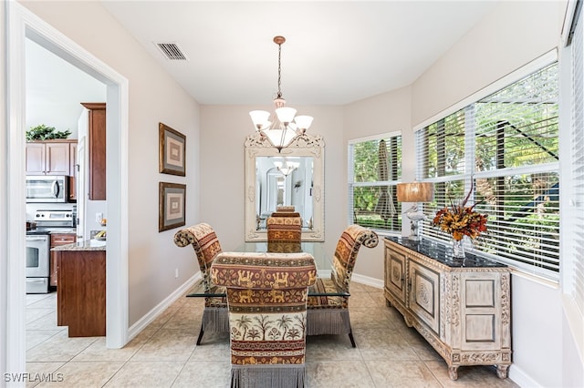 tiled dining space featuring an inviting chandelier