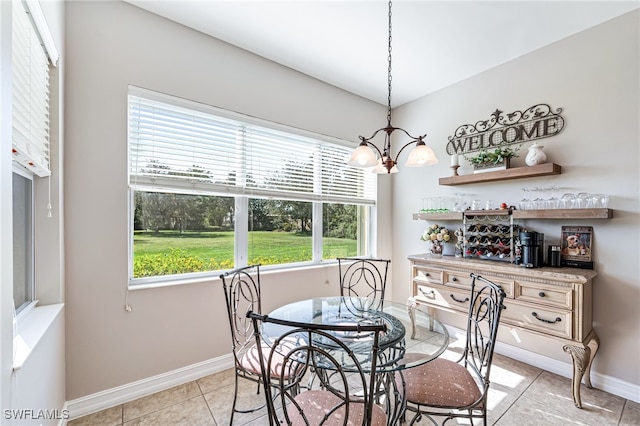 tiled dining room featuring an inviting chandelier