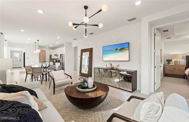 tiled living room with wood walls and a chandelier