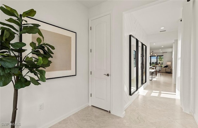 hallway with an inviting chandelier