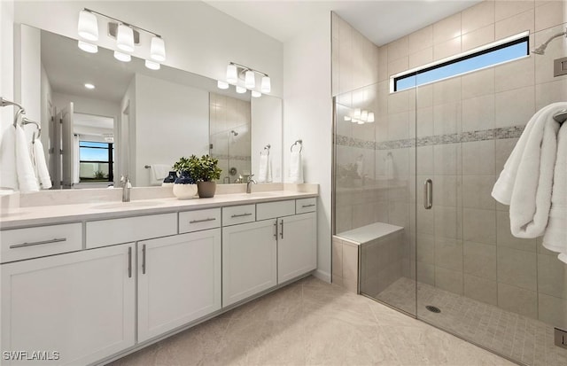 bathroom featuring a wealth of natural light, an enclosed shower, vanity, and tile patterned flooring