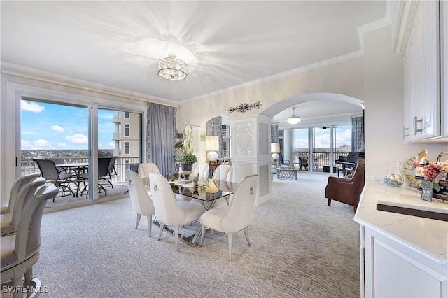 carpeted dining area with ornamental molding and a notable chandelier