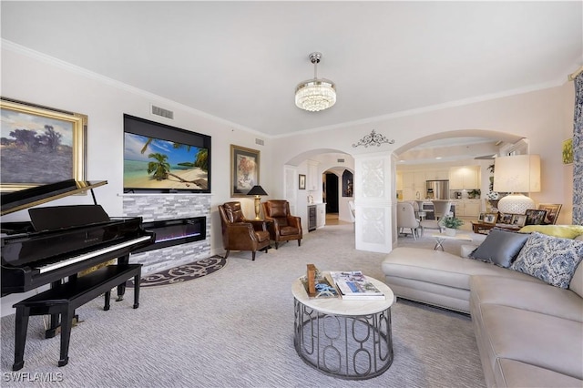 carpeted living room featuring ornamental molding and a stone fireplace