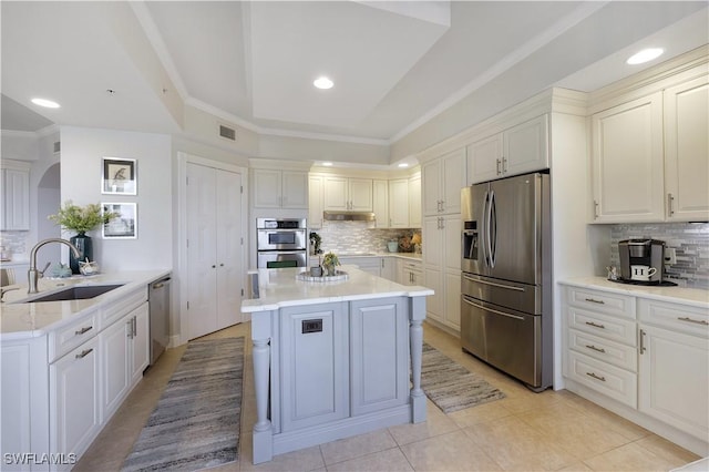 kitchen featuring tasteful backsplash, light tile patterned floors, sink, and stainless steel appliances