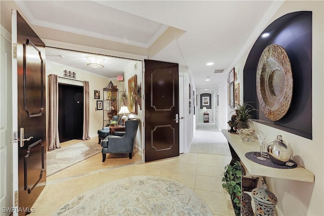 corridor with light tile patterned floors and crown molding