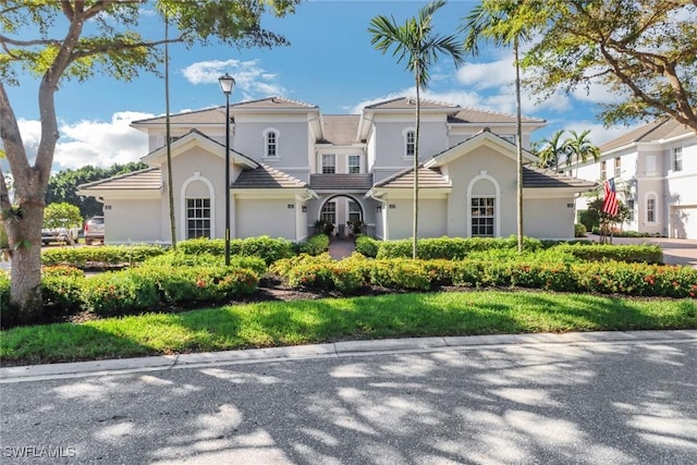 mediterranean / spanish house with a front lawn