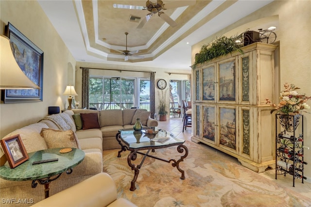 living room with ceiling fan, ornamental molding, a healthy amount of sunlight, and a raised ceiling