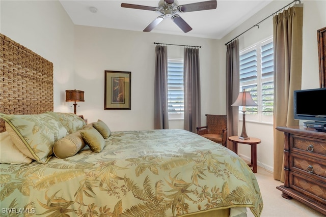 bedroom featuring ceiling fan, light colored carpet, and multiple windows