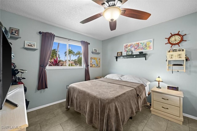 bedroom featuring ceiling fan, light tile patterned flooring, and a textured ceiling