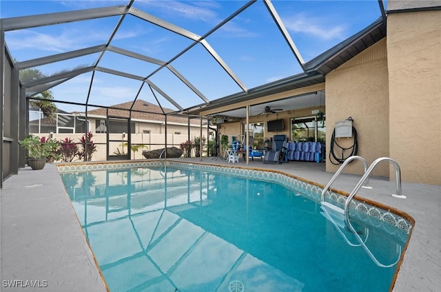 view of swimming pool with glass enclosure, a patio area, and ceiling fan