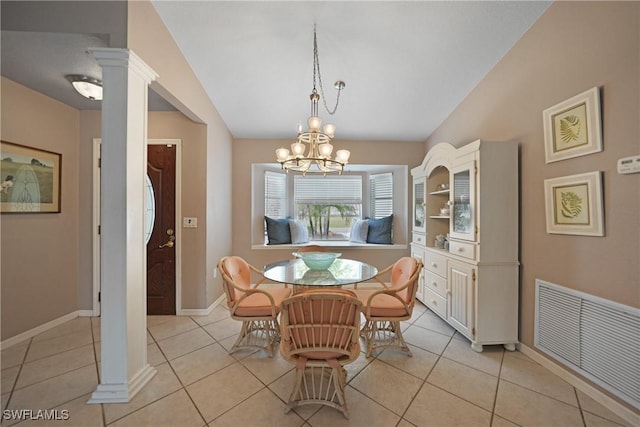 dining space with a chandelier, light tile patterned floors, and ornate columns