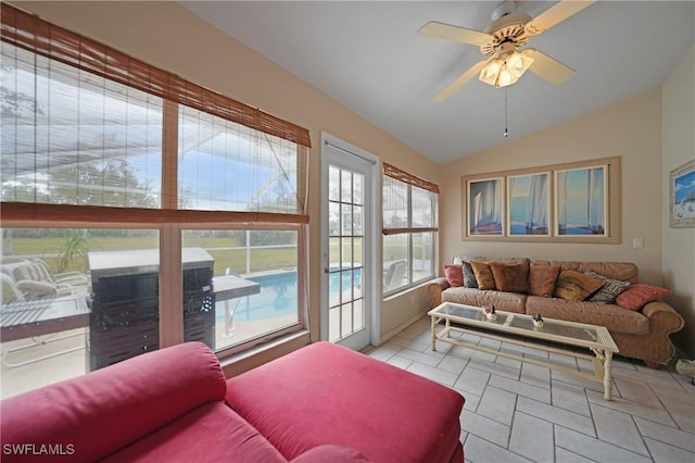 living room featuring ceiling fan, light tile patterned floors, and lofted ceiling