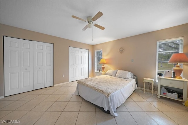 bedroom featuring multiple closets, light tile patterned floors, and ceiling fan