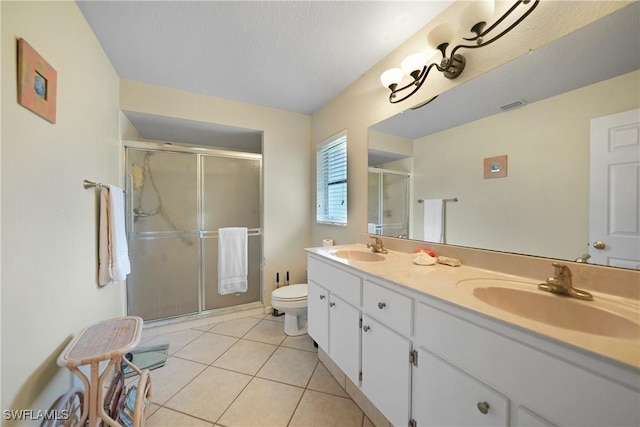 bathroom with an enclosed shower, vanity, and tile patterned flooring