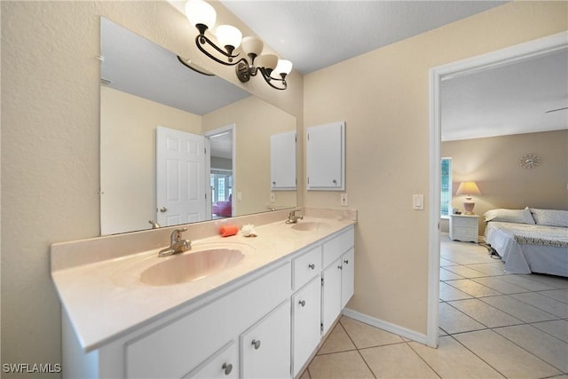 bathroom with a chandelier, tile patterned floors, and vanity