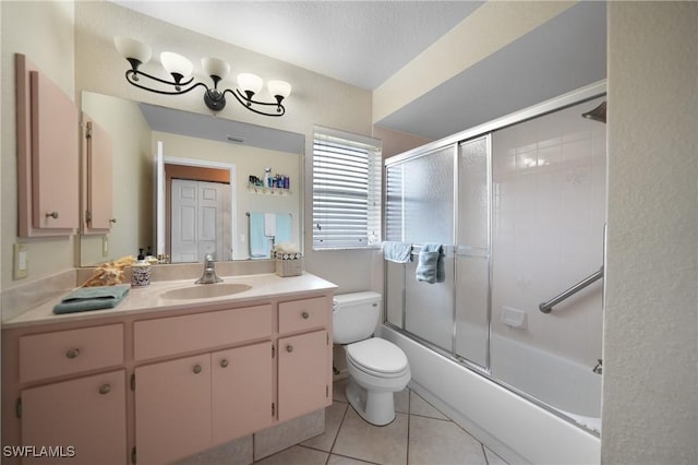 full bathroom featuring tile patterned floors, a textured ceiling, toilet, vanity, and bath / shower combo with glass door