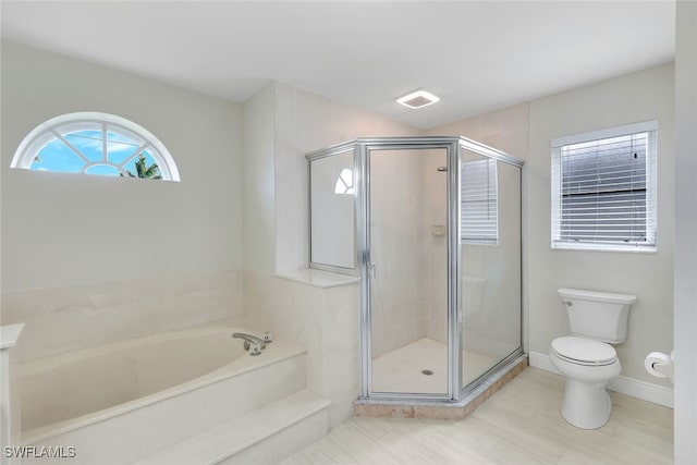 bathroom featuring shower with separate bathtub and toilet