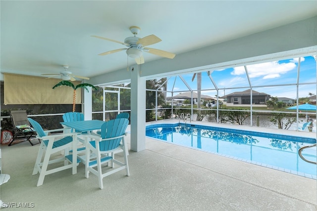 view of pool with a patio, a water view, ceiling fan, and glass enclosure