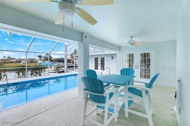 view of pool featuring ceiling fan, a patio, a water view, glass enclosure, and french doors