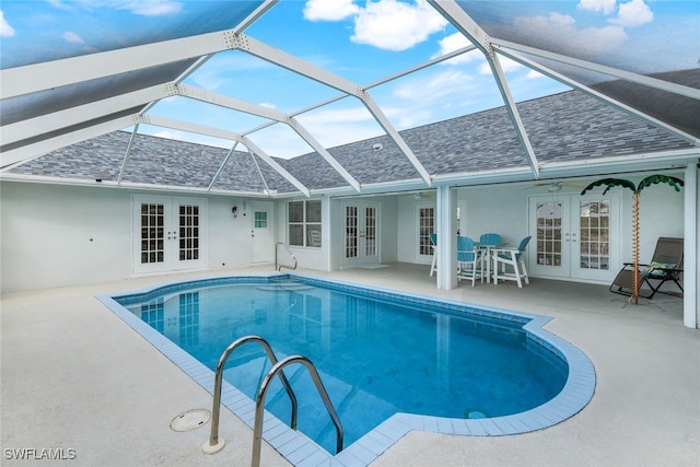 view of swimming pool with a patio, ceiling fan, glass enclosure, and french doors