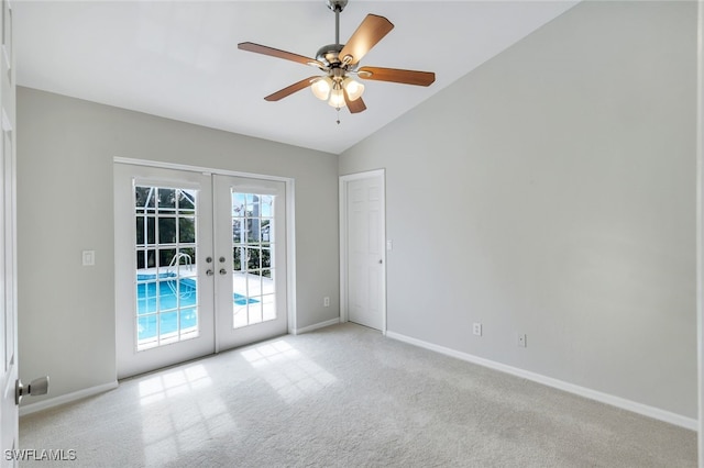 carpeted empty room with vaulted ceiling, french doors, and ceiling fan