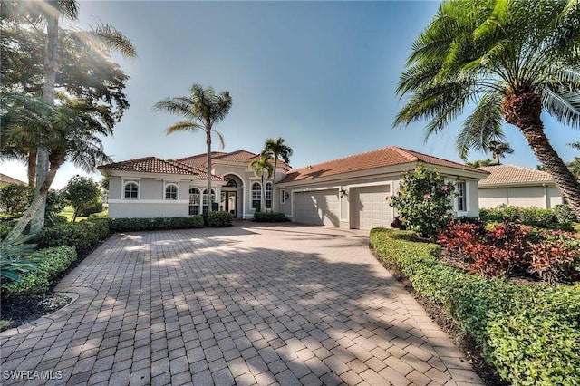 mediterranean / spanish home with a garage