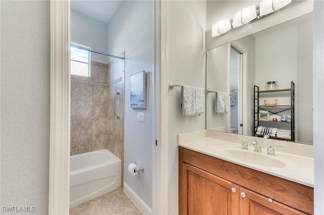 bathroom with tiled shower / bath combo, tile patterned floors, and vanity