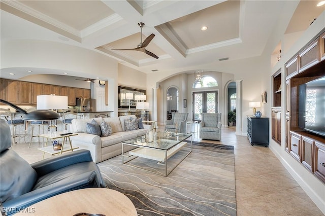 living room featuring ceiling fan, beamed ceiling, coffered ceiling, ornamental molding, and french doors