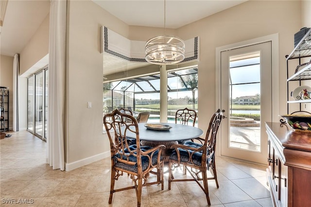 tiled dining space featuring plenty of natural light and an inviting chandelier