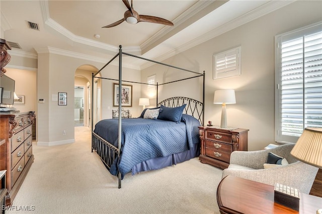 carpeted bedroom featuring ceiling fan, multiple windows, crown molding, and connected bathroom