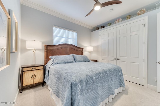 bedroom featuring ceiling fan, light colored carpet, a closet, and ornamental molding