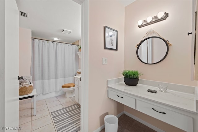 full bathroom with tile patterned floors, toilet, vanity, and shower / tub combo