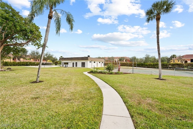 view of community with tennis court and a lawn