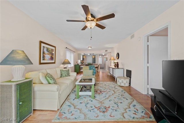 living room featuring ceiling fan and light hardwood / wood-style flooring