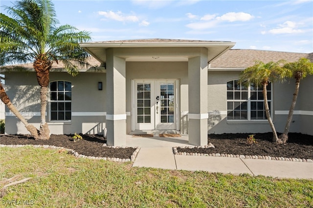 entrance to property with a lawn and french doors