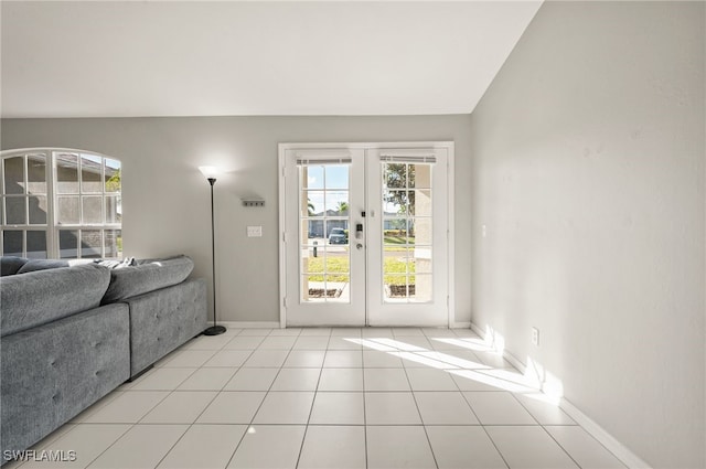 entryway featuring light tile patterned flooring, vaulted ceiling, and french doors