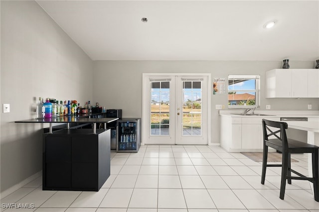 kitchen with french doors, beverage cooler, sink, and white cabinets