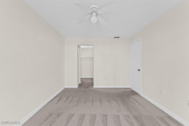 carpeted empty room featuring ceiling fan and a textured ceiling