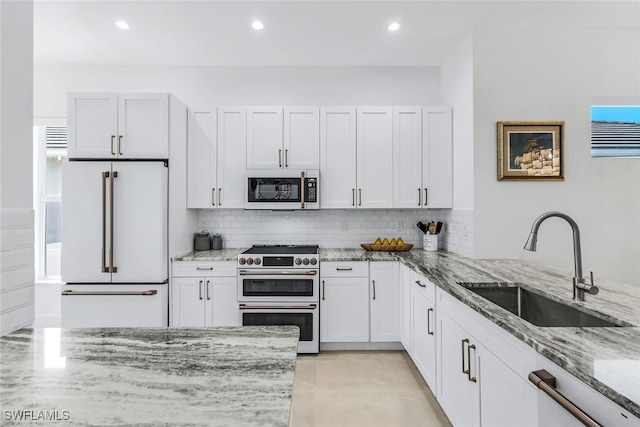 kitchen with sink, white cabinets, and high quality appliances