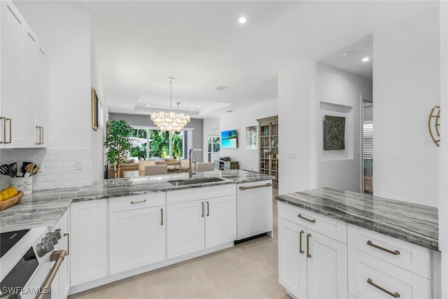 kitchen with white appliances, white cabinets, a tray ceiling, and sink