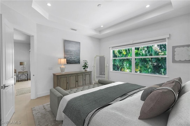 bedroom featuring a raised ceiling and light tile patterned flooring