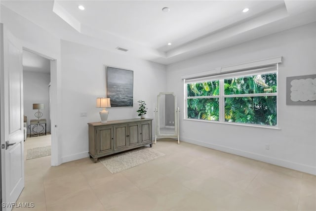 interior space featuring light tile patterned floors and a tray ceiling