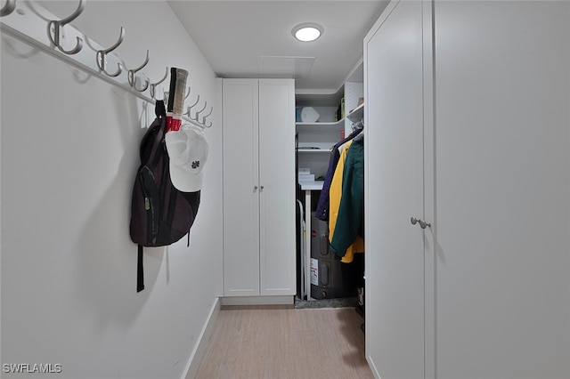 walk in closet with light hardwood / wood-style flooring