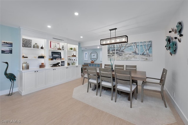 dining space with built in features and light wood-type flooring