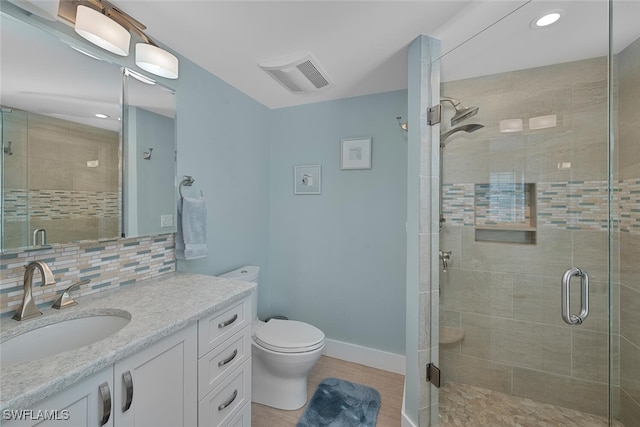 bathroom featuring decorative backsplash, walk in shower, vanity, and toilet