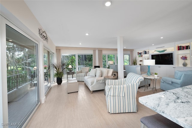 living room featuring built in features and light hardwood / wood-style flooring