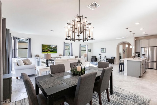 dining space with a chandelier and sink