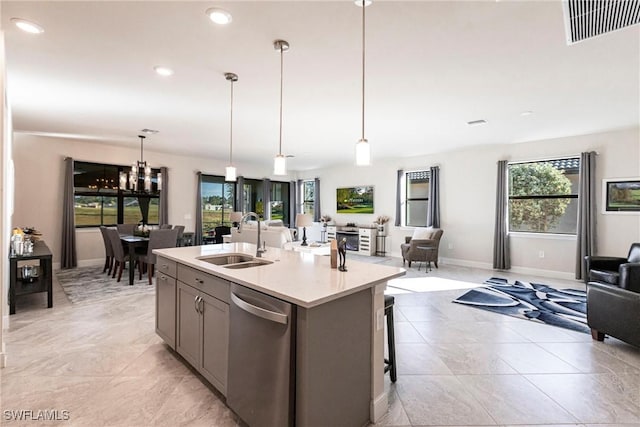 kitchen featuring decorative light fixtures, sink, a breakfast bar area, a kitchen island with sink, and stainless steel dishwasher