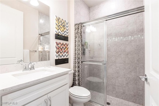 bathroom with vanity, toilet, and a shower with shower door